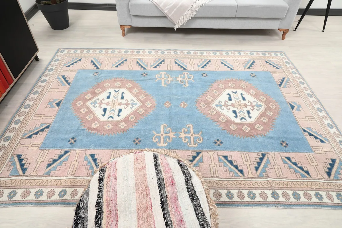 Full view of the blue and rose medallion rug in a living room, showing its scale