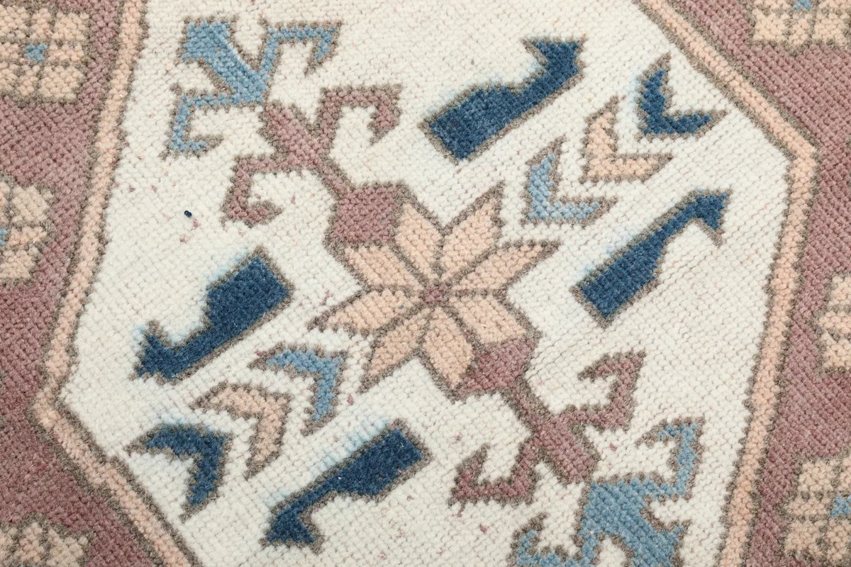 Extreme close-up of the intricate patterns within a medallion, showing blue, rose, and beige colors