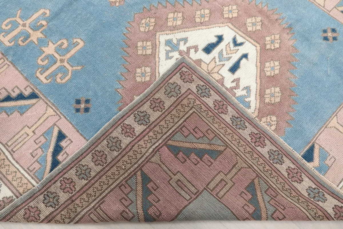 Folded corner of the rug, revealing the dense hand-knotted wool pile and cotton foundation