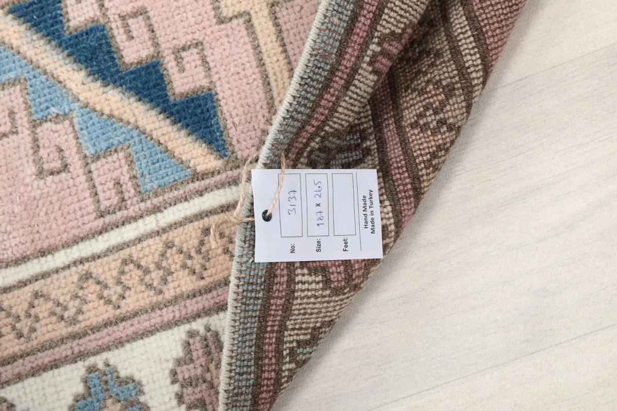 Close-up of the rug's label attached to the back, indicating its origin and material