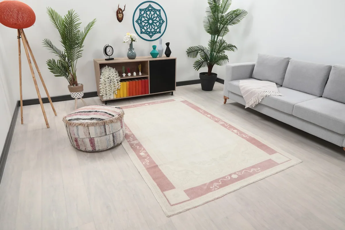 Angled view of the vintage rug in a living room, showing its full length and color