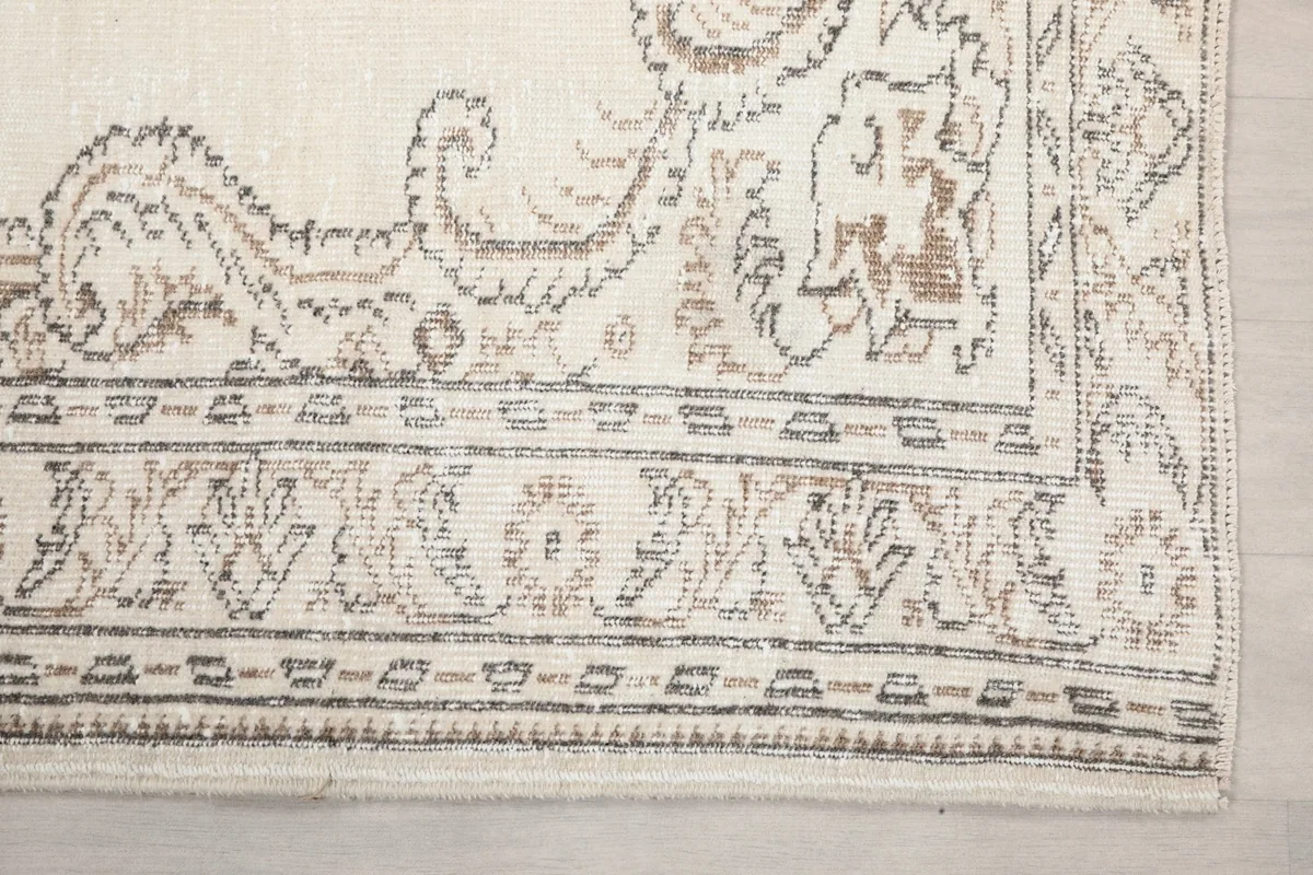 Detailed view of the rug's corner, showing the faded border design and subtle color variations