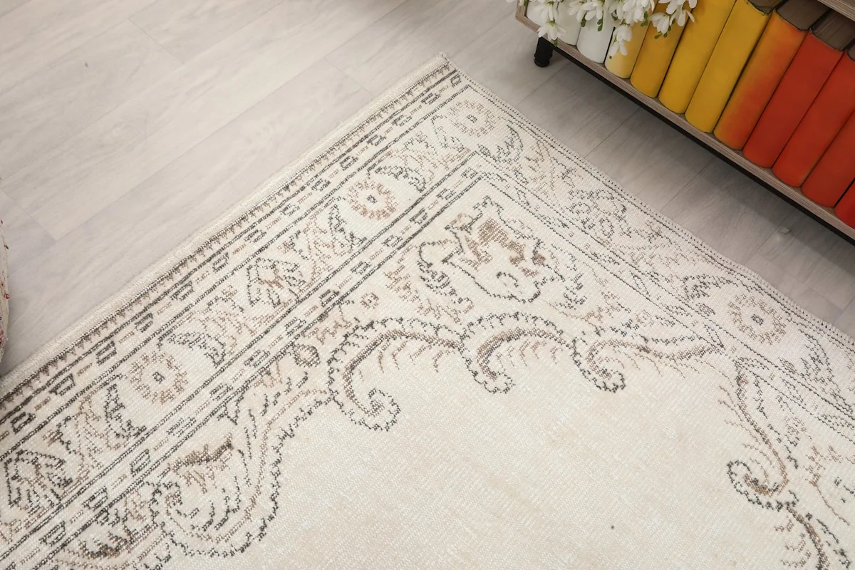 Close-up of the rug's border, revealing the detailed, faded scrollwork and geometric designs