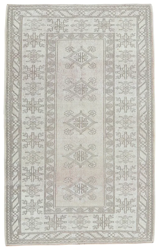 Full top view of the beige and tan geometric Anatolian rug on a white background.