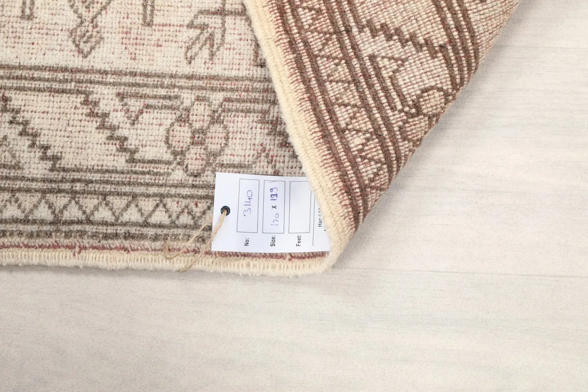 Detail of the rug's label with dimensions, tucked under a corner.