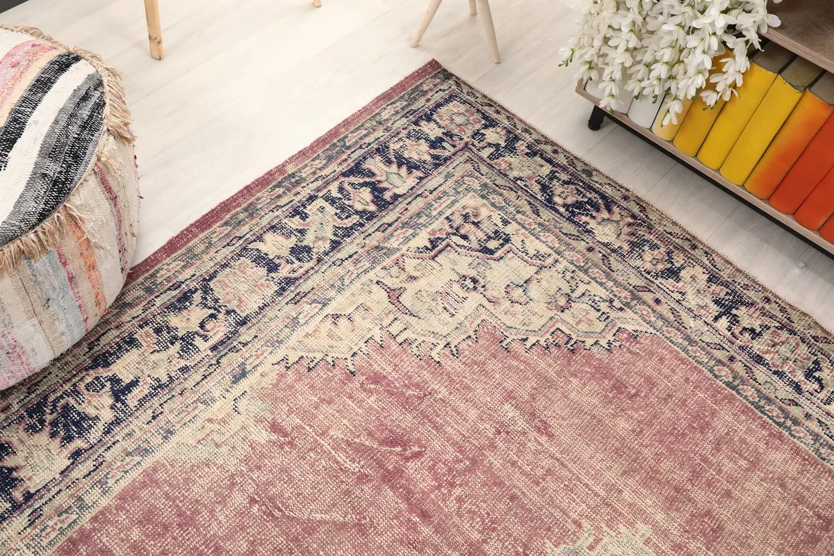 Corner view of the rug, showing the faded rose field and ornate border
