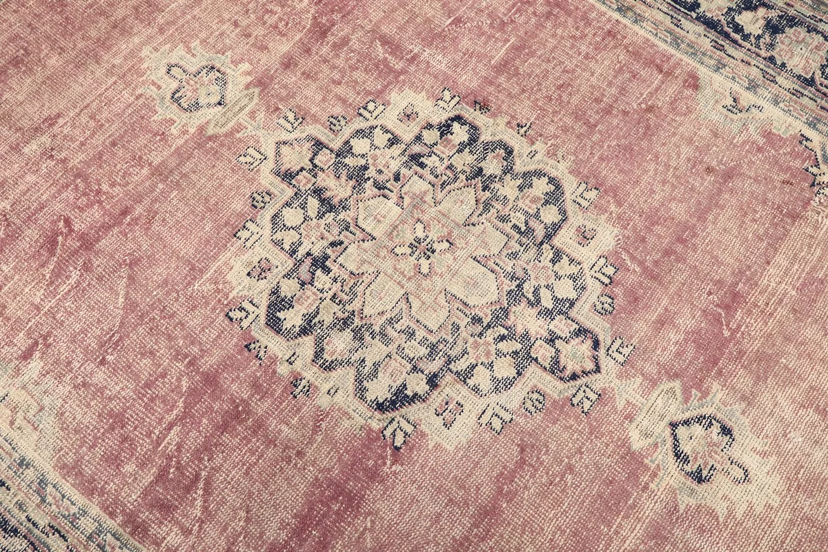 Close-up of the central medallion with navy and ivory details on the rose background