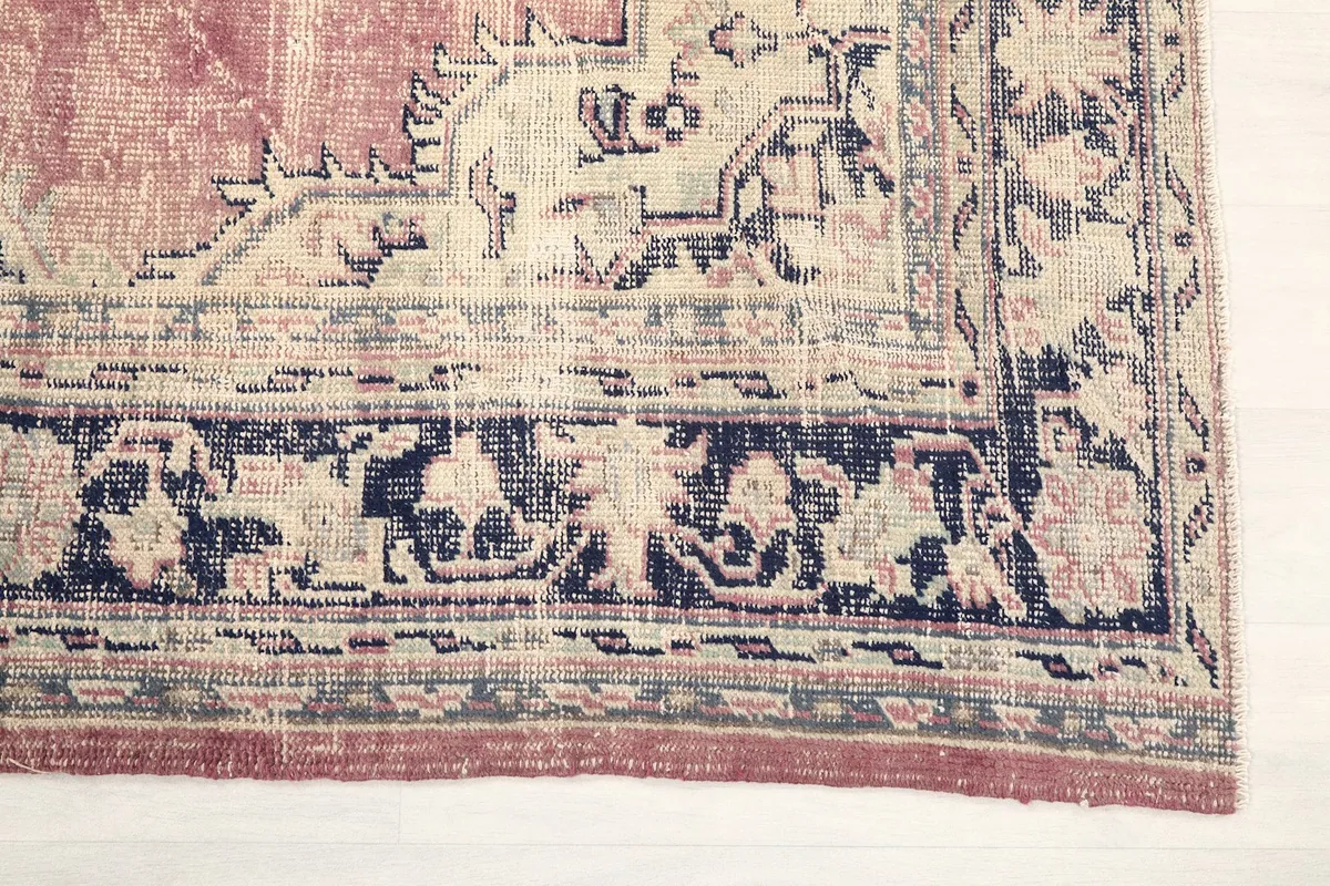 Detail of the navy and ivory border patterns on the rose vintage rug