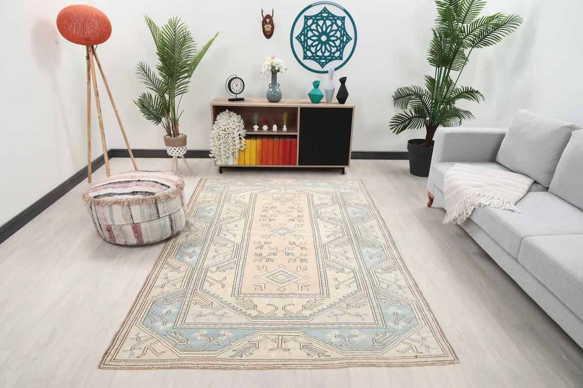 Vintage Anatolian rug displayed in a living room setting with a sofa and decor
