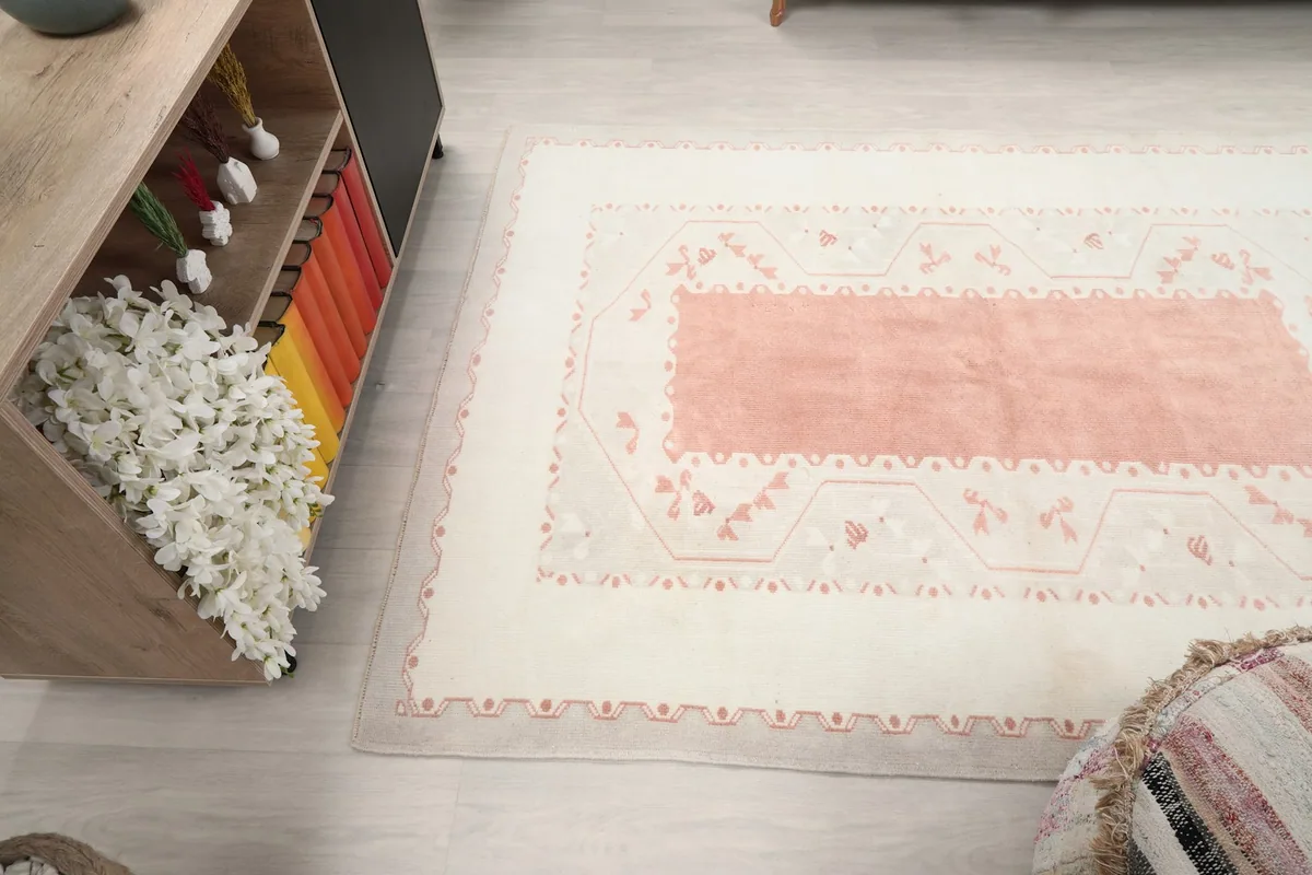 Angled view of the rug, showcasing its placement next to a wooden console with colorful books