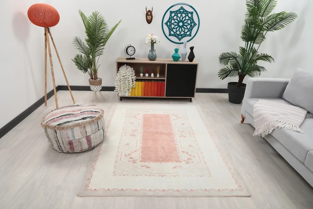 Vintage Anatolian rug in an ambient room setting with a light grey couch and wooden furniture