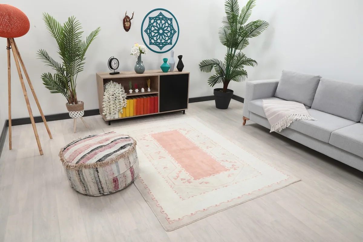 Area rug from a slightly different angle in a room with plants and a decorative pouf