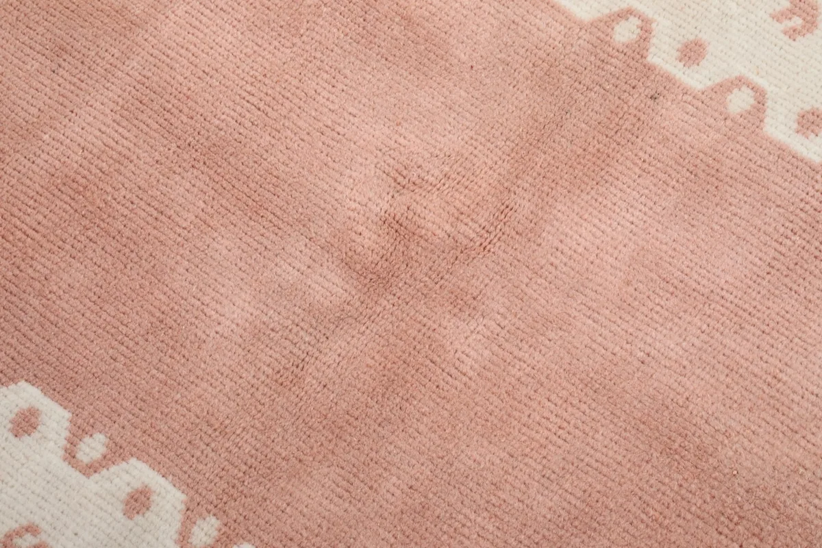 Close-up detail of the pink central field, showing the texture and subtle color variations of the wool pile