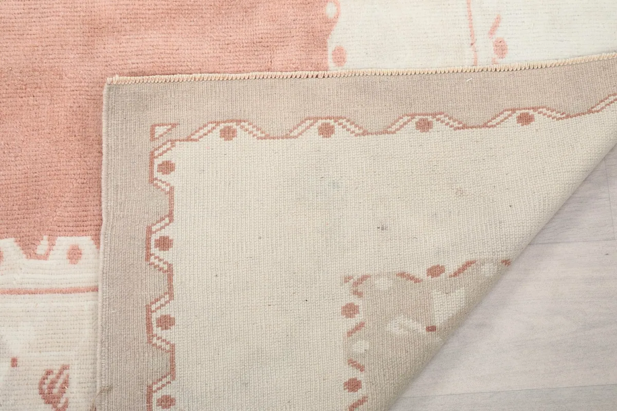 Close-up of the rug's folded corner, showing the wool pile and cotton foundation texture
