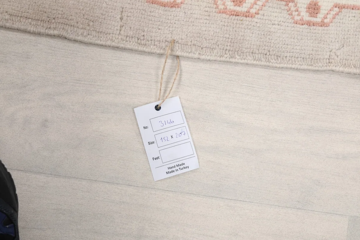 Tag showing the rug's dimensions and origin, 'Hand Made in Turkey', on a light wooden floor