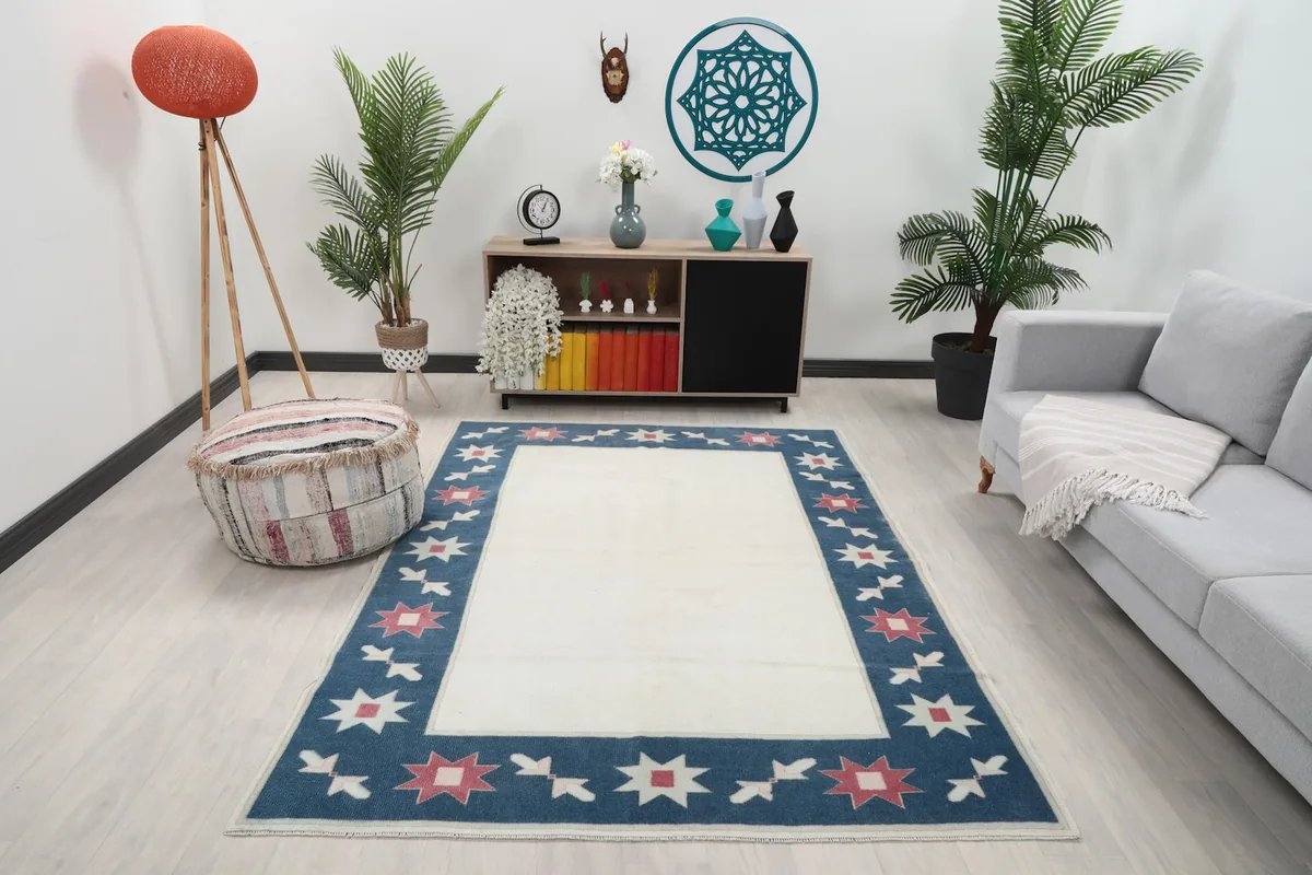 Ivory and blue rug in a modern living room setting with a sofa and decor