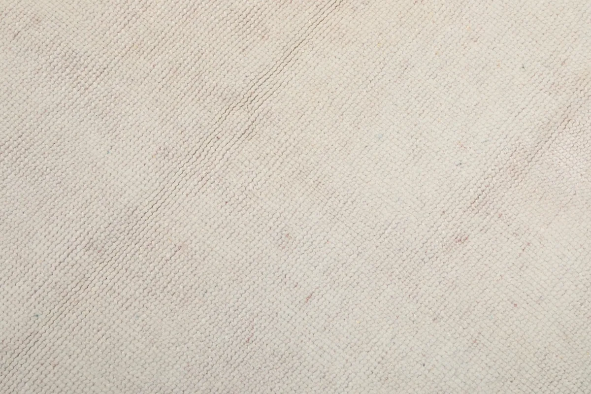 Close-up of the rug's cotton foundation and hand-knotted construction from the back