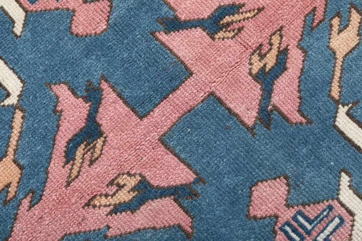 Texture detail of the low wool pile, showing the hand-knotted construction and color variations