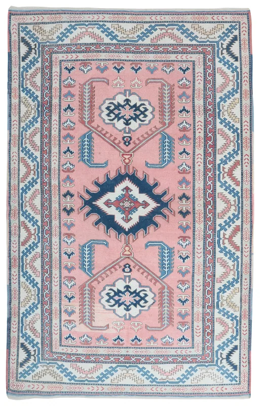 Full overhead view of the pink, navy, and cream geometric vintage Anatolian area rug.