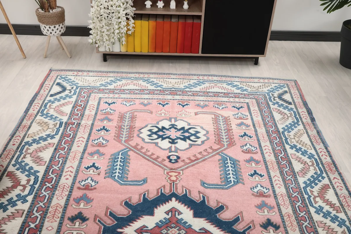 Overhead angled shot of the top half of the pink rug, showcasing its detailed patterns and colors.