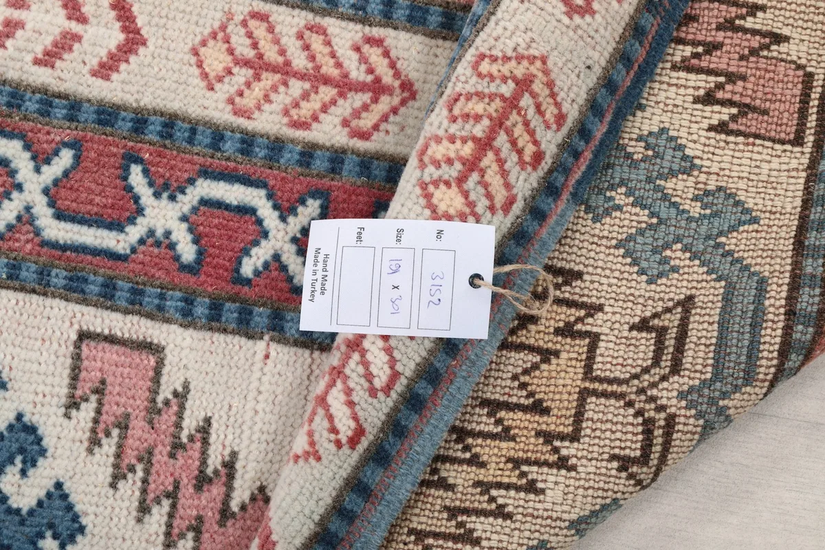 Detail of the rug's label and a folded edge, showing the texture and construction.