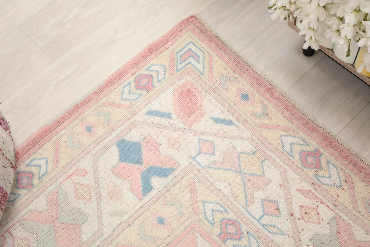 Corner perspective of the rug, showing the border design and faded colors