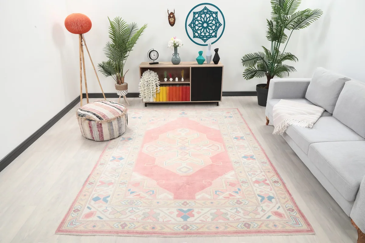 Vintage pink and beige rug styled in a modern living room setting from an angle