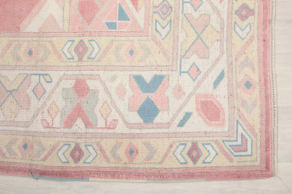 Detailed shot of the corner border showing blue and yellow motifs on a beige field