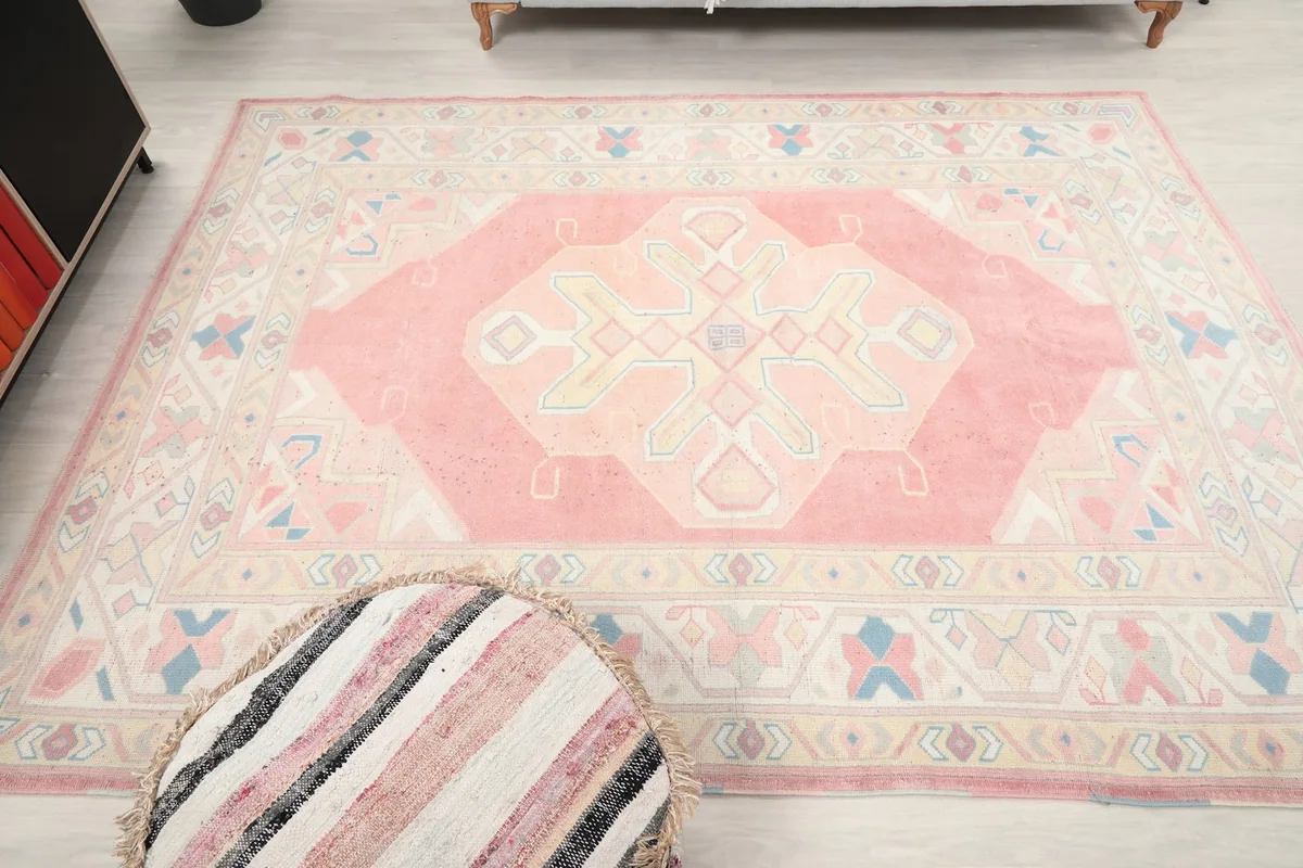 Direct overhead shot of the pink and beige rug, emphasizing its medium size