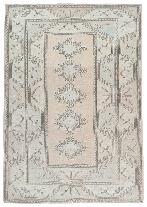 Full top view of the beige and cream vintage Anatolian rug with charcoal geometric and floral patterns