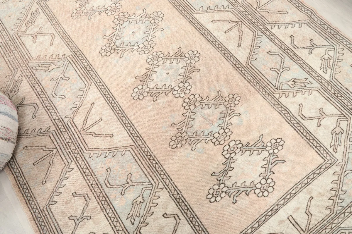 Overhead detail of the central floral and geometric motifs on the beige field
