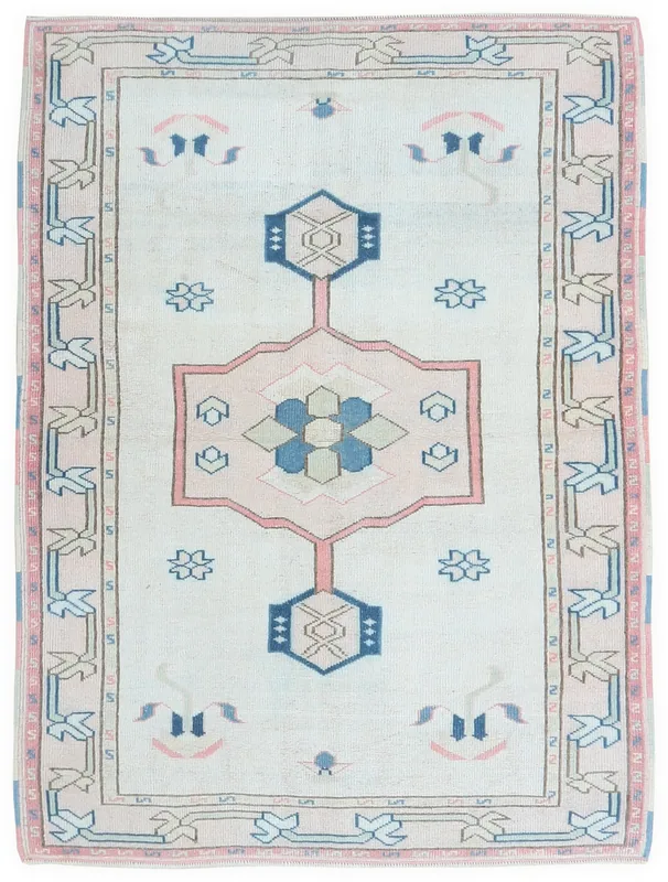 Full top view of the vintage ivory, pink, and blue geometric medallion rug