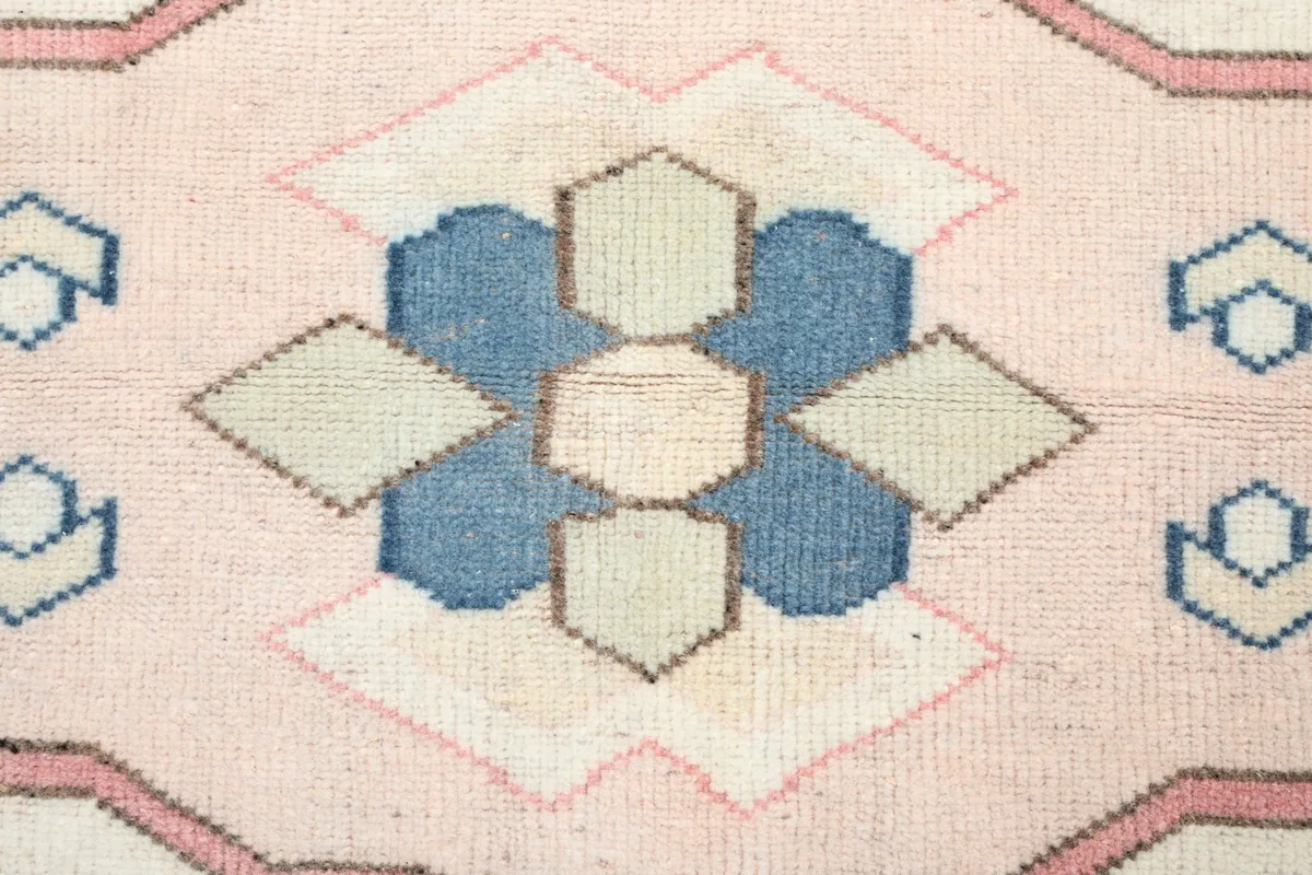 Close-up of the central medallion showing blue, tan, and ivory geometric shapes