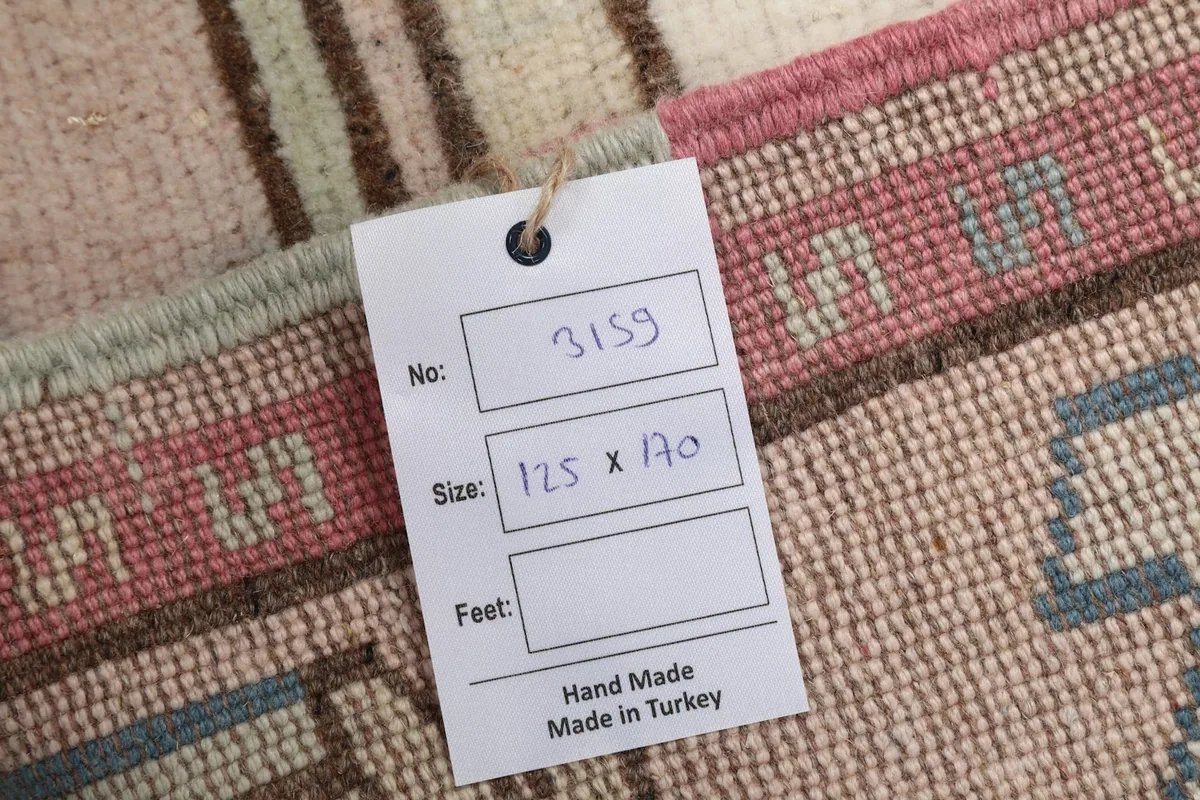 Tag showing the rug's dimensions in centimeters and confirmation of hand-made in Turkey