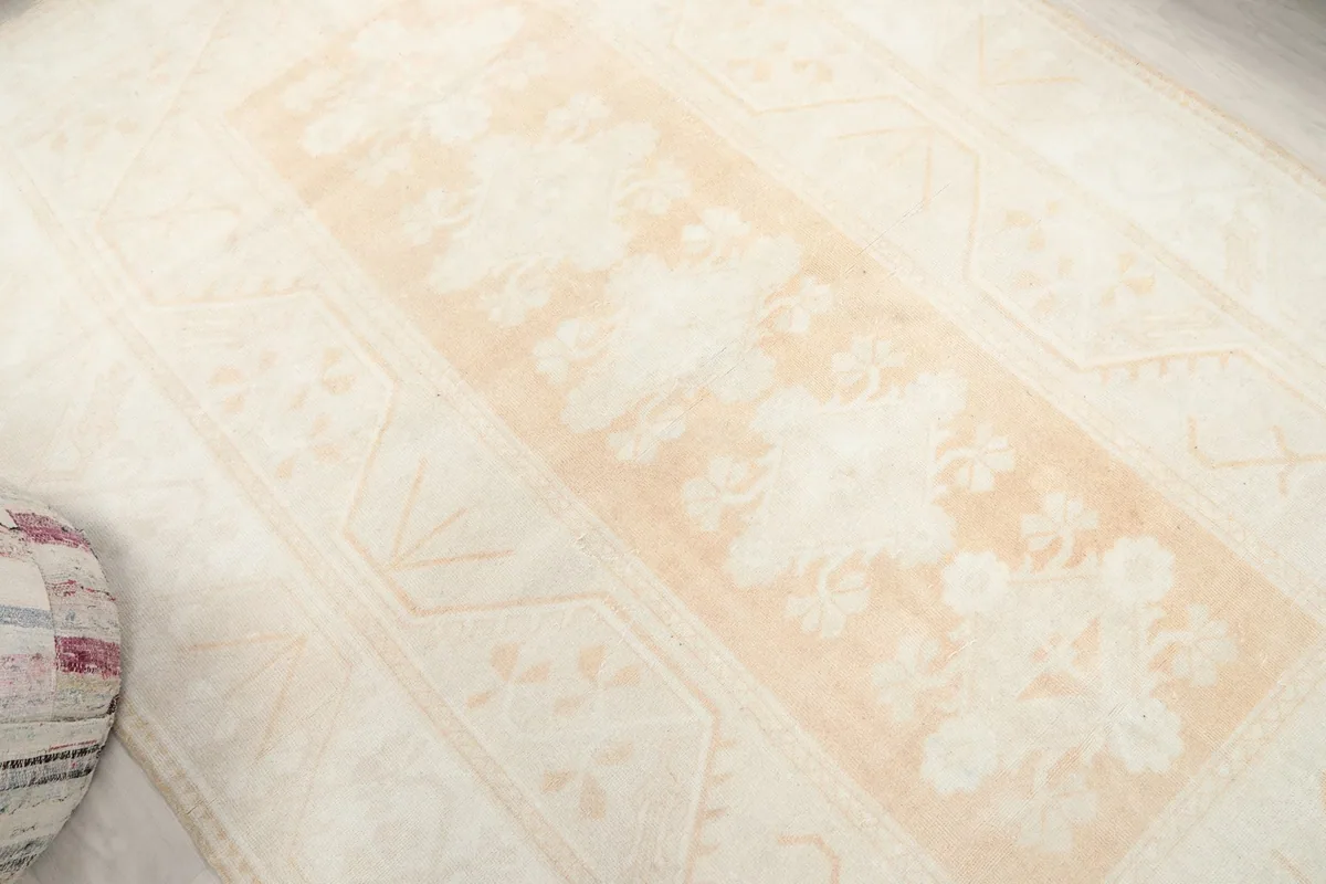 Overhead angle showcasing the central beige medallion and surrounding ivory field.