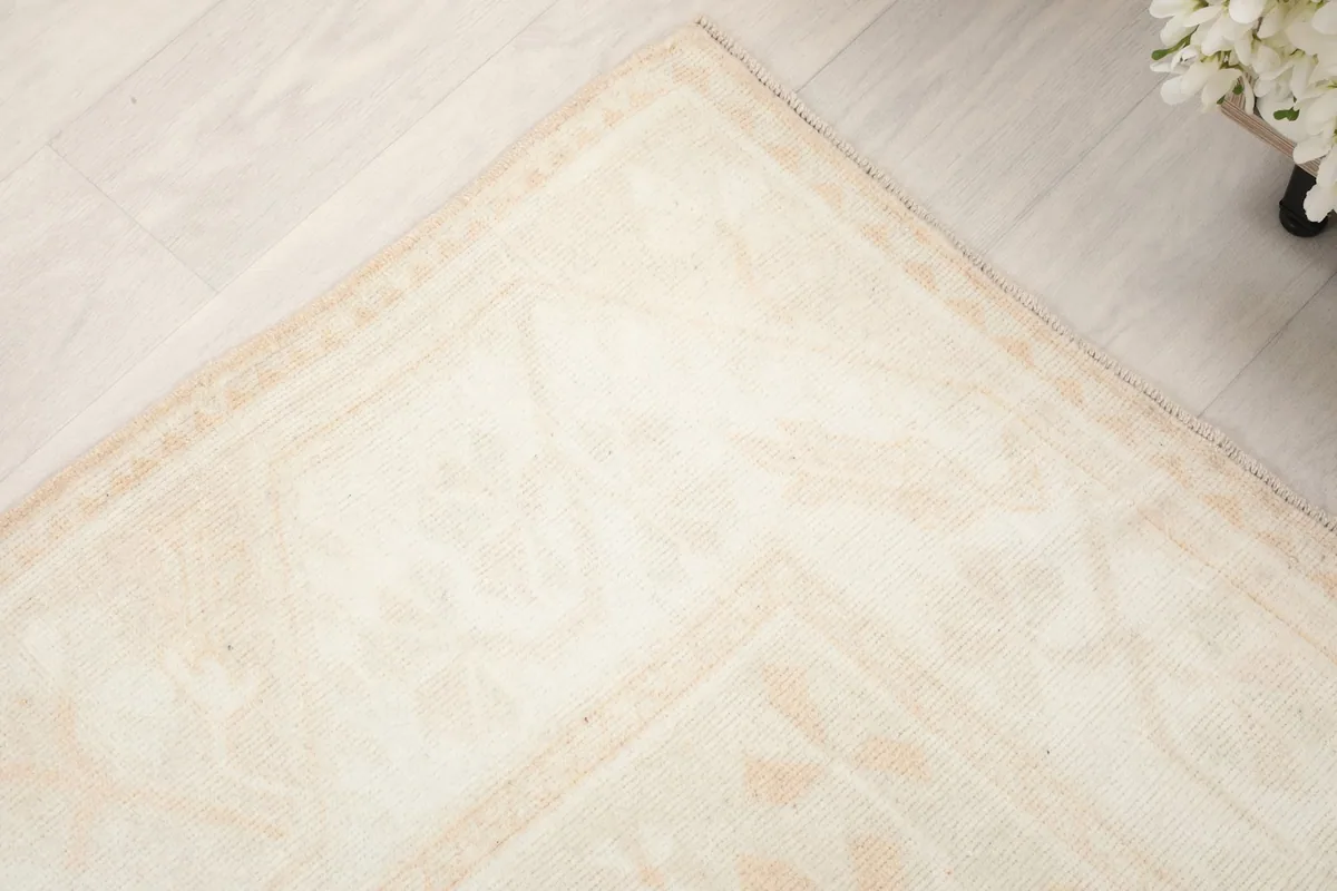 Corner detail of the rug, illustrating the subtle color variations and border design.