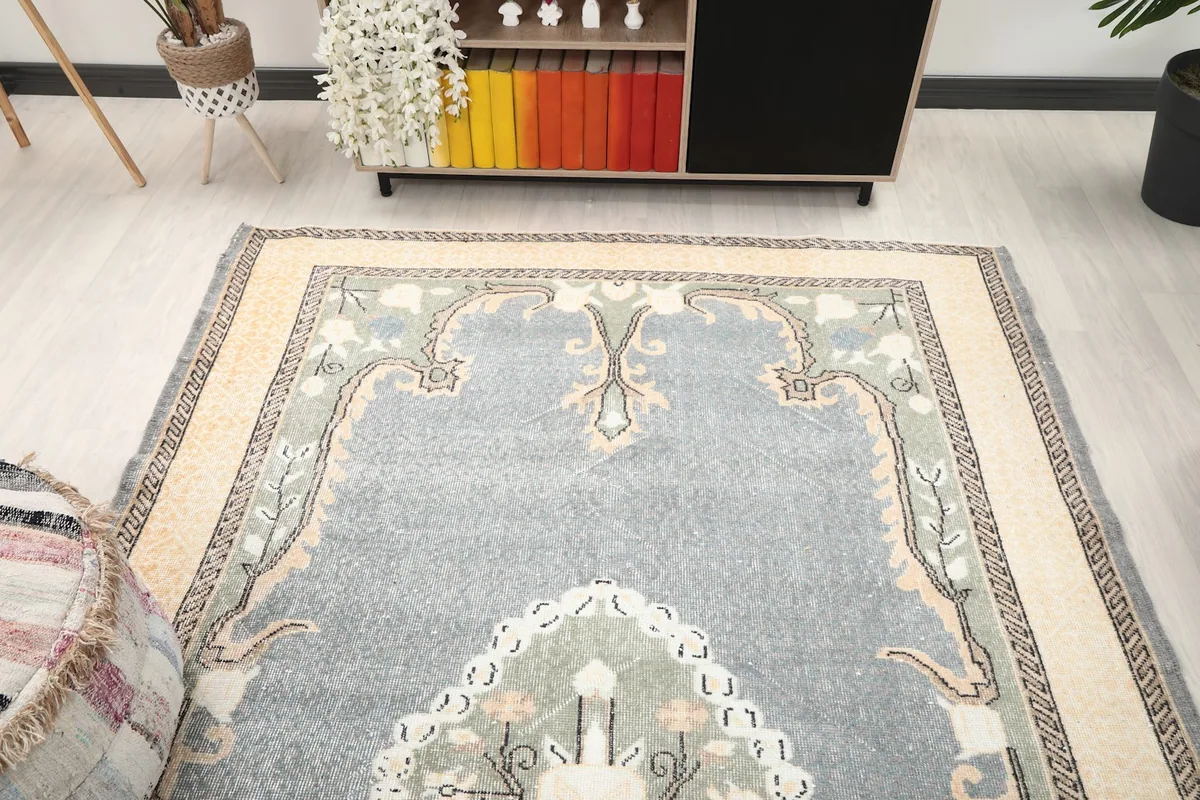 Overhead angle shot showcasing the gray rug's medallion and border in a room setting