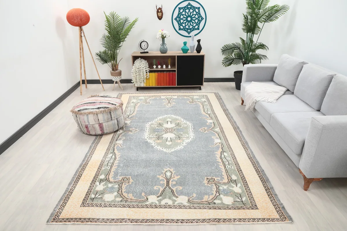 Vintage gray Anatolian rug displayed in a bright living room with a light gray sofa