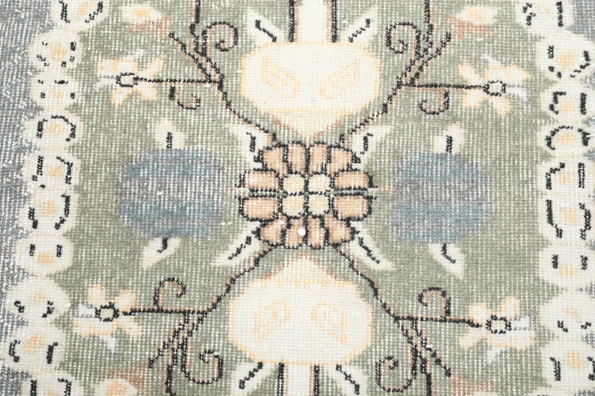 Detailed view of the intricate floral and stylized motifs within the medallion