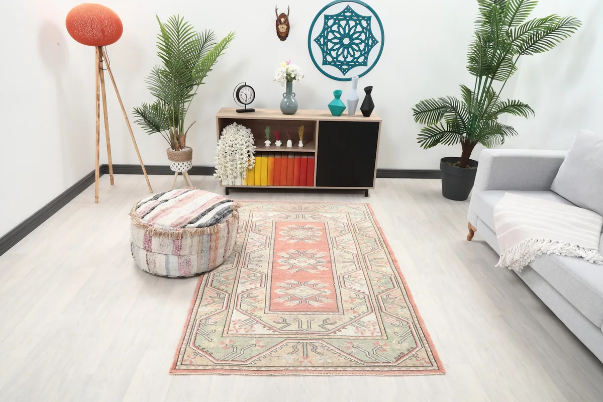 Vintage Anatolian rug displayed in a living room setting with a sofa and ottoman