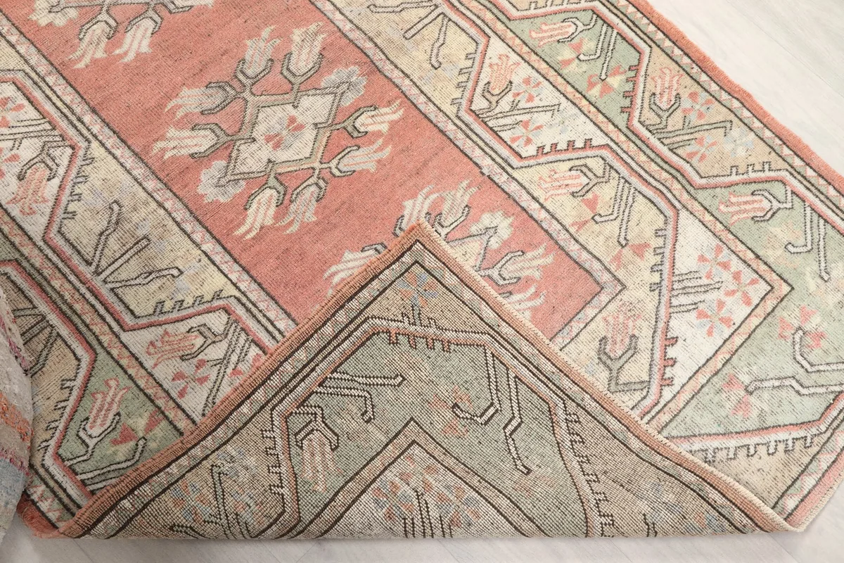 Folded corner of the rug revealing the hand-knotted wool pile and cotton foundation