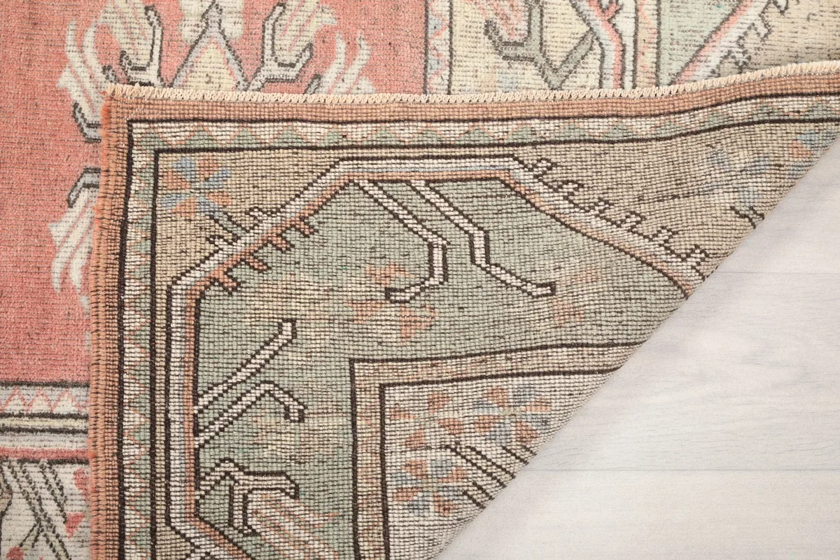 Underside view of the rug's corner, showcasing the weaving and construction details