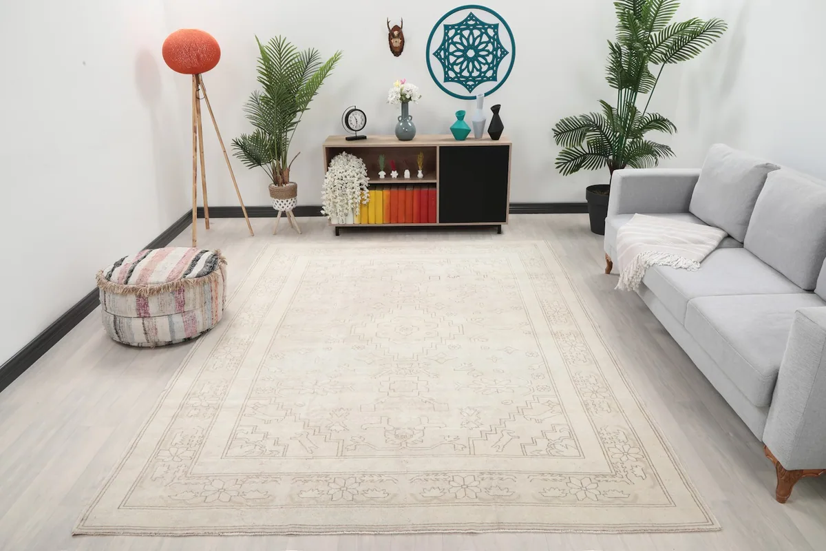 Ivory vintage rug displayed in a living room setting with a light gray sofa and modern decor.