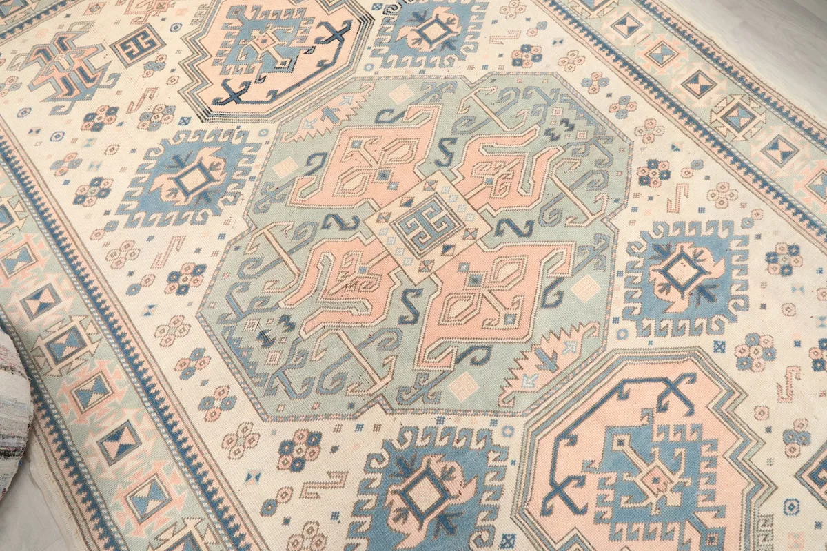 Overhead detail of the central medallion and surrounding geometric motifs in blue, rose, and ivory.