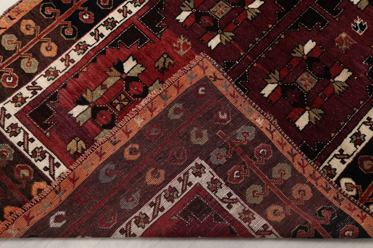 Folded corner of the rug revealing the back and thickness of the hand-knotted wool pile