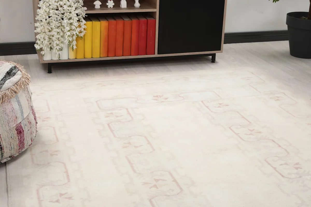 Close-up view of the cream field and subtle rose geometric patterns on the rug