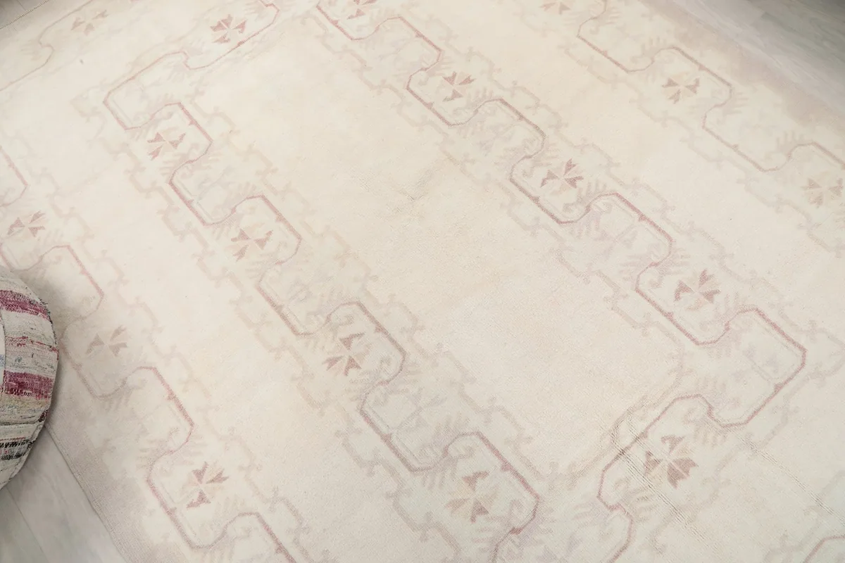 Overhead view showing the overall geometric design and soft colors of the rug