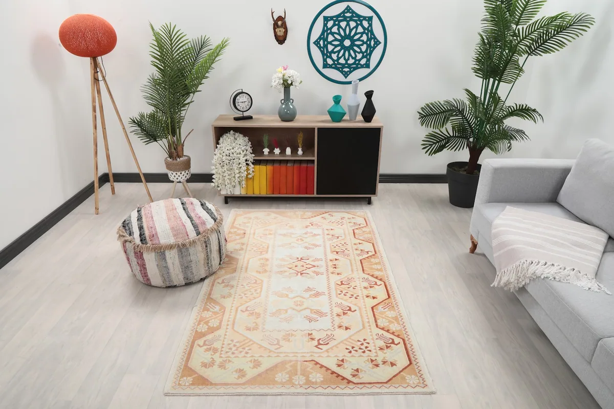 Ivory and orange vintage rug displayed in a living room setup from an overhead angle