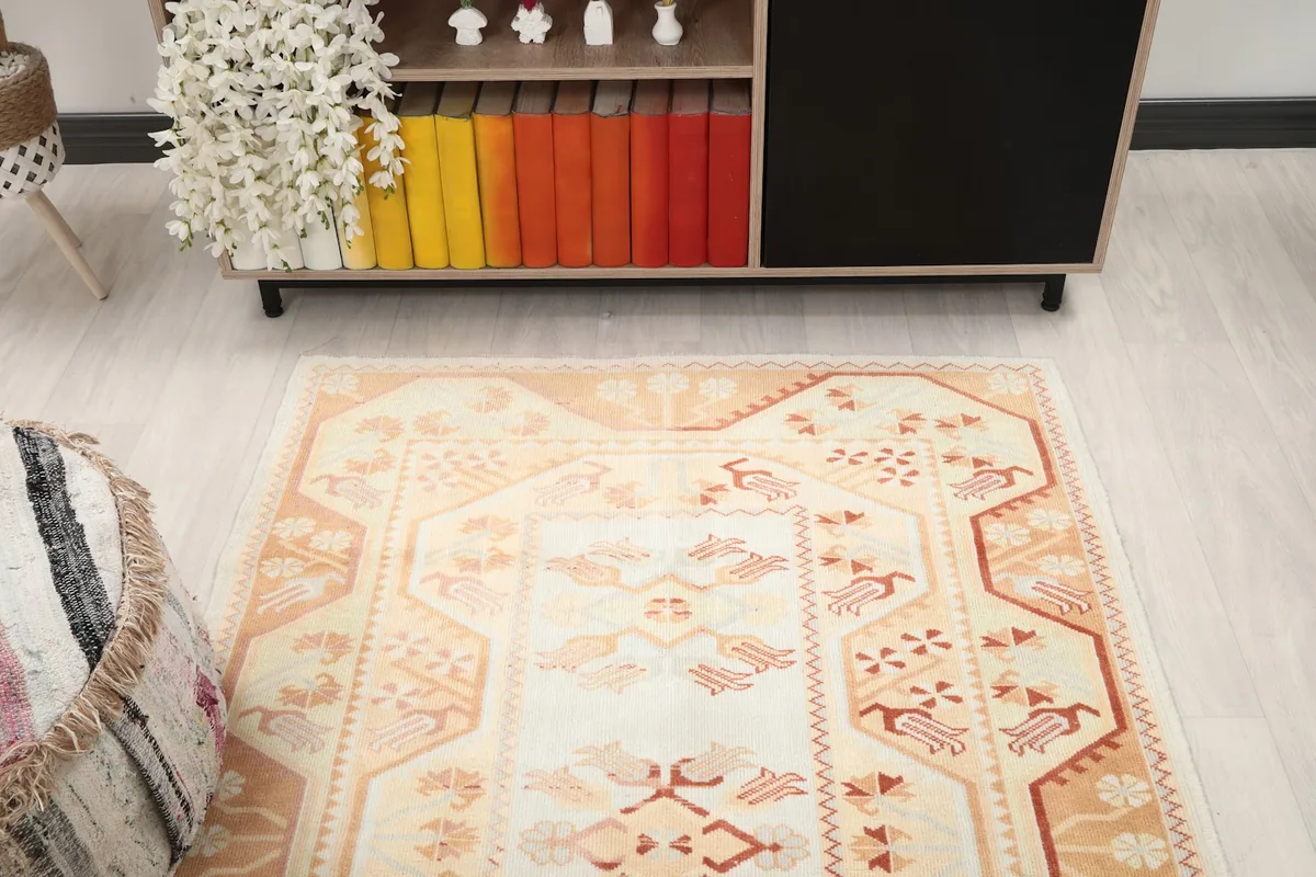 Overhead view of the ivory and orange vintage rug in a living room setting
