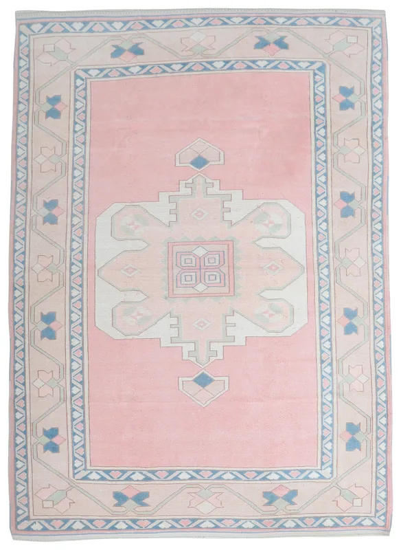 Full overhead view of the pink beige vintage Anatolian rug with geometric medallion.